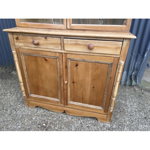 46 - A continental style pine dresser with glazed top over two drawers and two cupboard doors 110x45 x 20... 