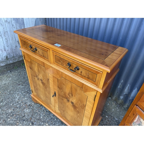 53 - A reproduction yew wood two drawer cupboard together with a pine tallboy chest