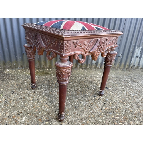 69 - An ormate carved window seat stool with Union Jack upholstered top 57 x57x64