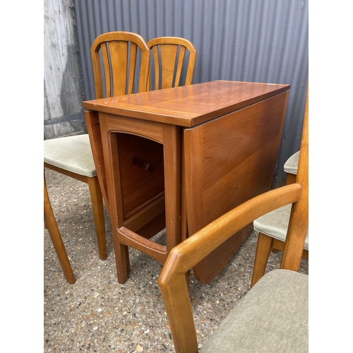 74 - A TEAK DROP LEAF DINING TABLE AND SIX CHAIRS BY MEREDEW