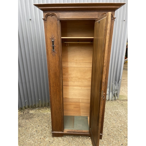 8 - An early 20th century oak mirror door wardrobe with carved details 100x45x196