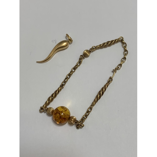 844 - 18ct Gold Squiggle Pendant, weight 1 gm and gold bracelet with Amber bead weight 5.7 gms