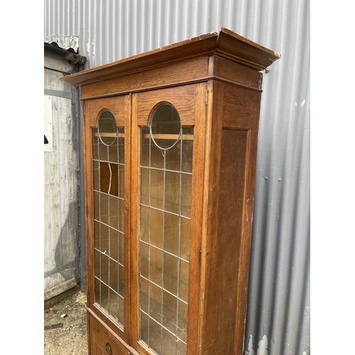 9 - An art nouveau oak bookcase with leaded glass doors (glass a/f) 104x40x186