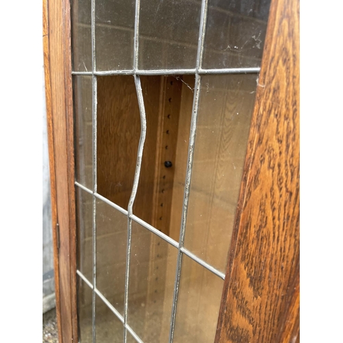 9 - An art nouveau oak bookcase with leaded glass doors (glass a/f) 104x40x186