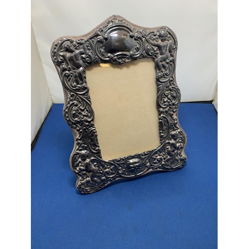 840 - Ornate Hallmarked Silver Photo frame decorated with cherubs, 19 x 25 cms