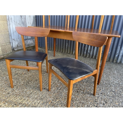 23 - A danish style rectangular teak dining table together with four teak chairs with black vinyl seats