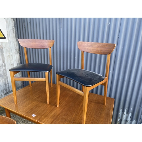 23 - A danish style rectangular teak dining table together with four teak chairs with black vinyl seats