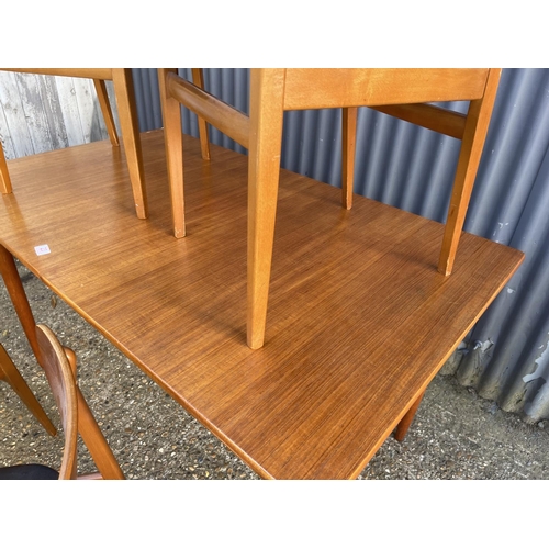 23 - A danish style rectangular teak dining table together with four teak chairs with black vinyl seats