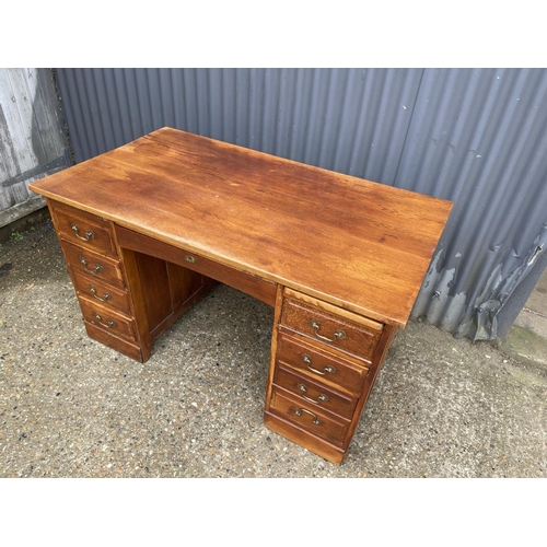 45 - A 20th century oak kneehole office desk 132x77x77