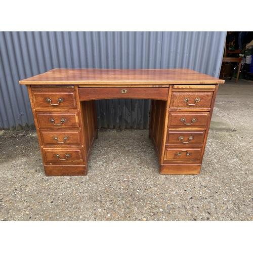 45 - A 20th century oak kneehole office desk 132x77x77