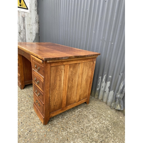 45 - A 20th century oak kneehole office desk 132x77x77