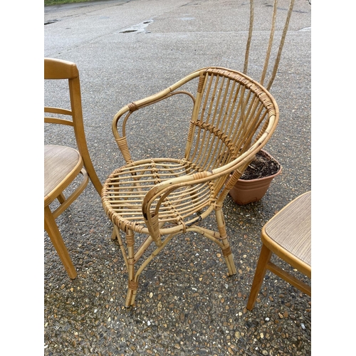 56 - Wicker chair, two kitchen chairs and plant