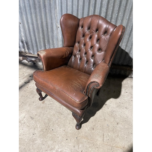 59 - A brown leather chesterfield wing arm chair AF