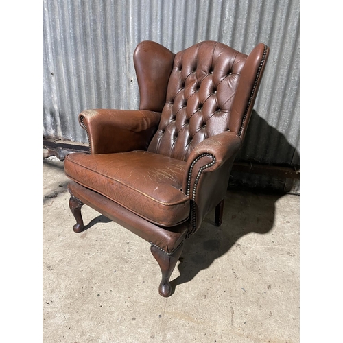 59 - A brown leather chesterfield wing arm chair AF