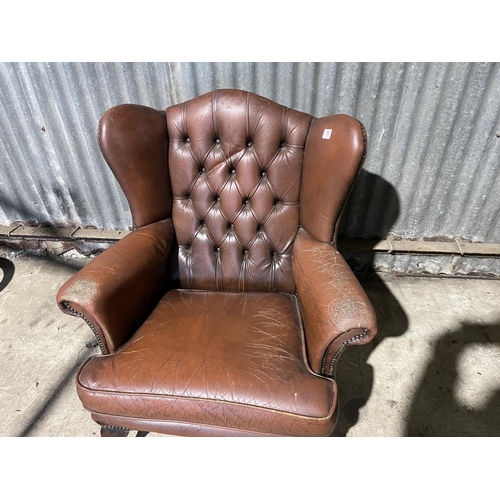 59 - A brown leather chesterfield wing arm chair AF