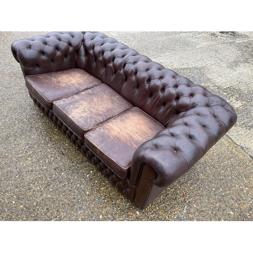 60 - A brown leather chesterfield three seater sofa