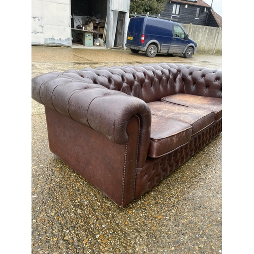 60 - A brown leather chesterfield three seater sofa