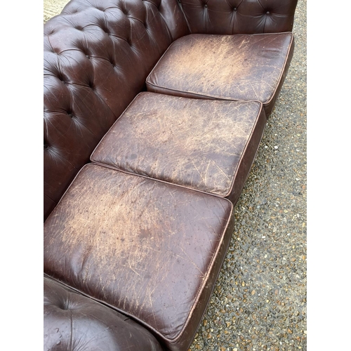 60 - A brown leather chesterfield three seater sofa