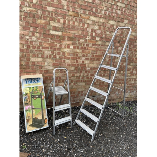 101 - Two pairs of aluminium step ladders together with a black and decker sack barrow (boxed)