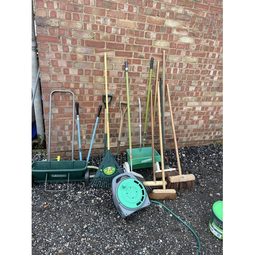 102 - A collection of garden tools including hose and bucket of manure garden feed