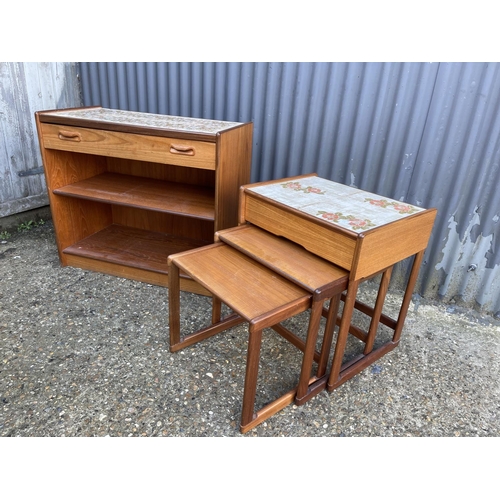 108 - A mid century teak tile top sideboard / bookcase together with a teak tile top nest of three with dr... 