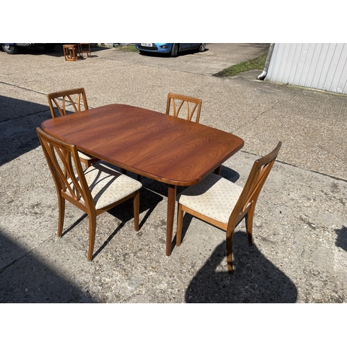 110 - A g plan teak extending dining table together with four g plan teak dining chairs