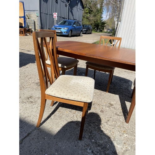 110 - A g plan teak extending dining table together with four g plan teak dining chairs