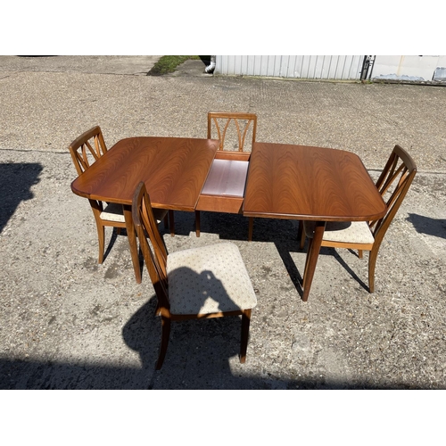 110 - A g plan teak extending dining table together with four g plan teak dining chairs