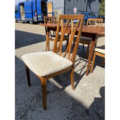 110 - A g plan teak extending dining table together with four g plan teak dining chairs