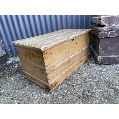 129 - An antique pine trunk together with two other pine trunks