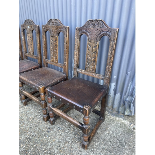 134 - A set of four carved oak dining chairs with leather seats