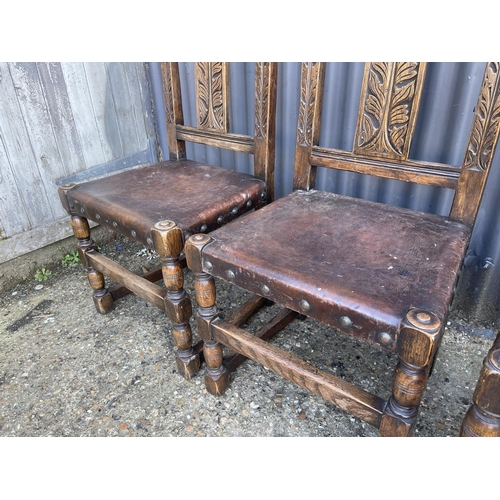 134 - A set of four carved oak dining chairs with leather seats