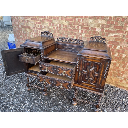 15 - An oak Jacobean revival sideboard with ornate carved decoration.  154x 56 x120