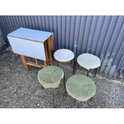 156 - A drop leaf kitchen table together with four stacking stools