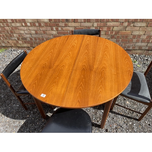 19 - A mid century Macintosh teak extending circular dining table together with four matching chairs with... 