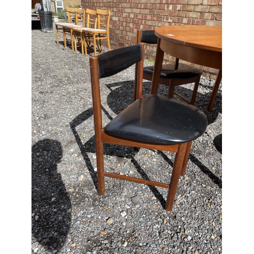 19 - A mid century Macintosh teak extending circular dining table together with four matching chairs with... 