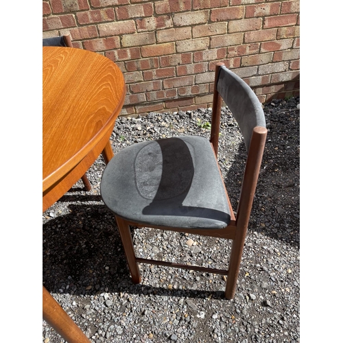 19 - A mid century Macintosh teak extending circular dining table together with four matching chairs with... 