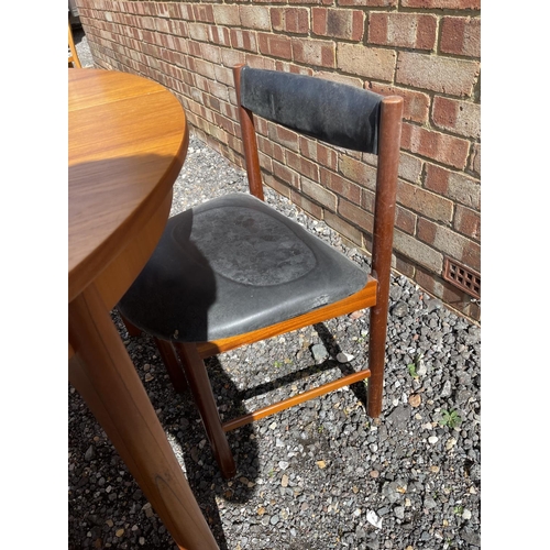 19 - A mid century Macintosh teak extending circular dining table together with four matching chairs with... 