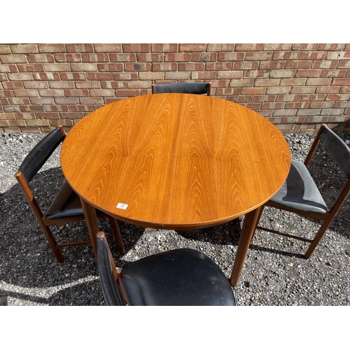 19 - A mid century Macintosh teak extending circular dining table together with four matching chairs with... 