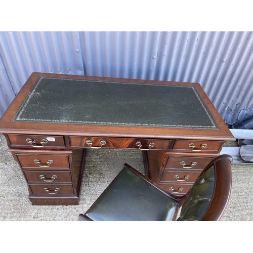 192 - A reproduction mahogany twin pedestal desk with a green leather top  together with a green buttoned ... 