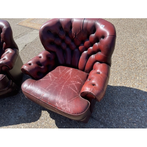 199 - A pair of oxblood red leather chesterfield armchairs