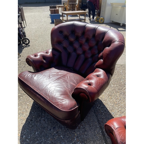 199 - A pair of oxblood red leather chesterfield armchairs