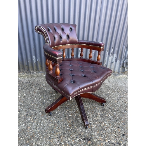 218 - A burgundy leather chesterfield captains style swivel desk chair