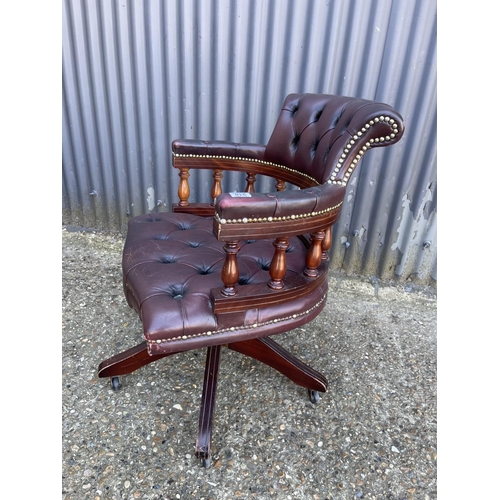 218 - A burgundy leather chesterfield captains style swivel desk chair