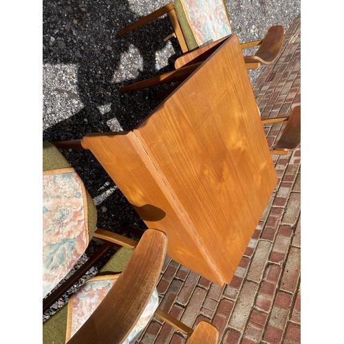 22 - A teak drop leaf table together with four chairs