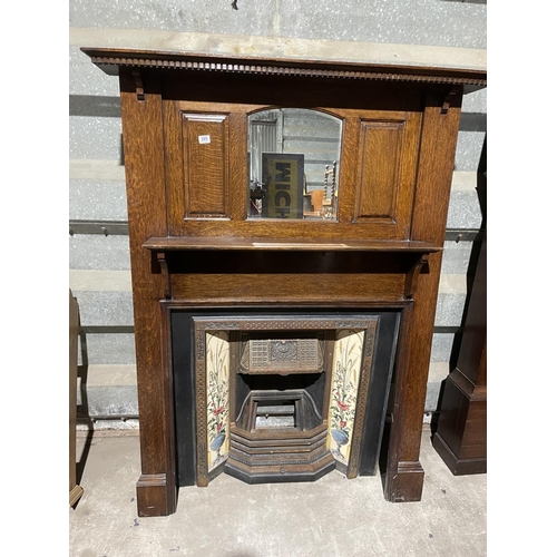 289 - A cast iron sitting room fire place with tiled features, together with oak fire surround with mirror... 