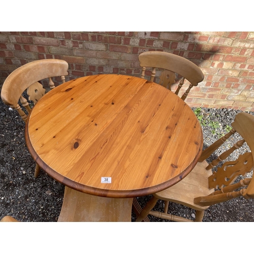 38 - A circular pine kitchen table and four chairs 90cm diameter