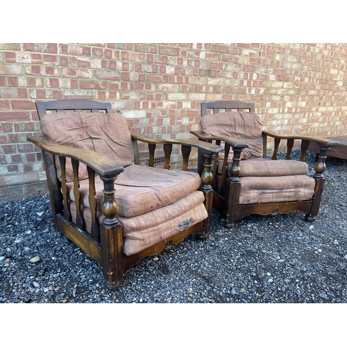 4 - A pair of early 20th century oak framed easy chairs with sliding seat and adjustable backs a/f