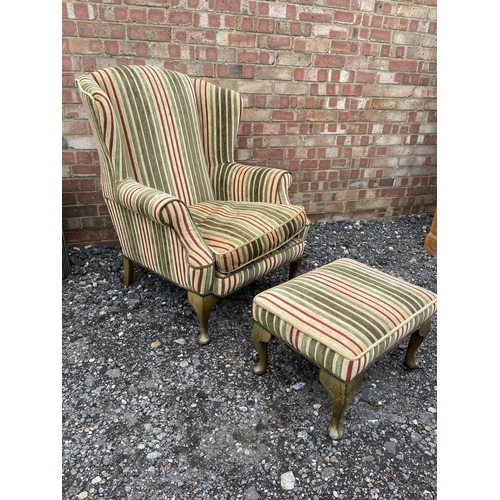 40 - A modern wing back armchair  with striped upholstery together with matching footstool