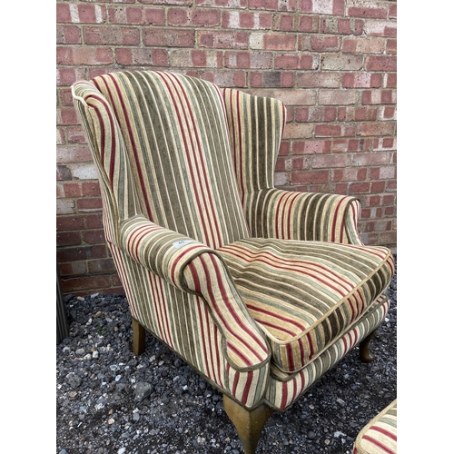 40 - A modern wing back armchair  with striped upholstery together with matching footstool